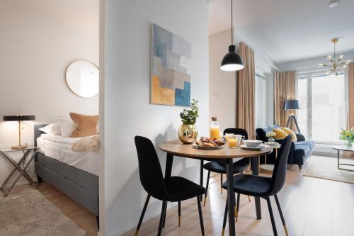 a room with a table and chairs and a bedroom at Premier Homes Pori Center Jazz in Pori