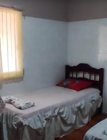ein Schlafzimmer mit einem Bett in einem Zimmer mit einem Fenster in der Unterkunft HOTEL E RESTAURANTE BOM GOSTO 