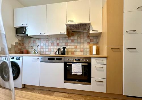 a kitchen with white cabinets and a stove top oven at Die Stadtkanzlei in Klagenfurt