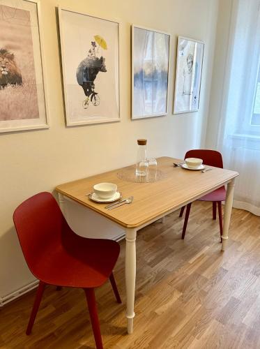 a dining room table with two chairs and a table with glasses at Die Stadtkanzlei in Klagenfurt
