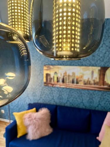 two cats sitting on a blue couch under two lights at Die Stadtkanzlei in Klagenfurt
