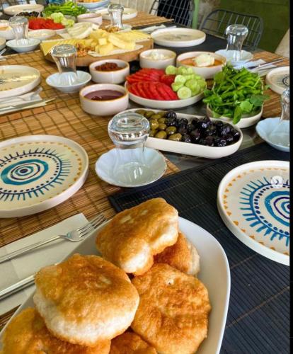 una mesa con platos de comida y cuencos de verduras en Dia Urla, en Urla
