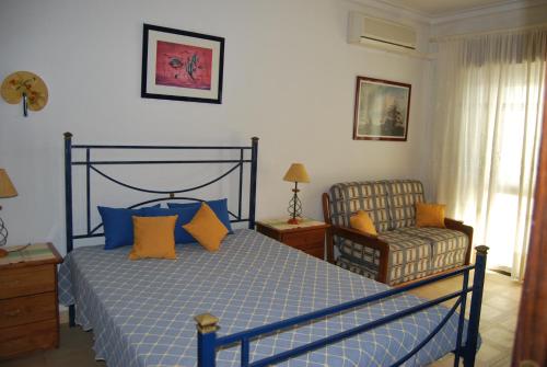 a bedroom with a bed and a chair at Apartment At Monte Gordo Beach Ocean View in Monte Gordo