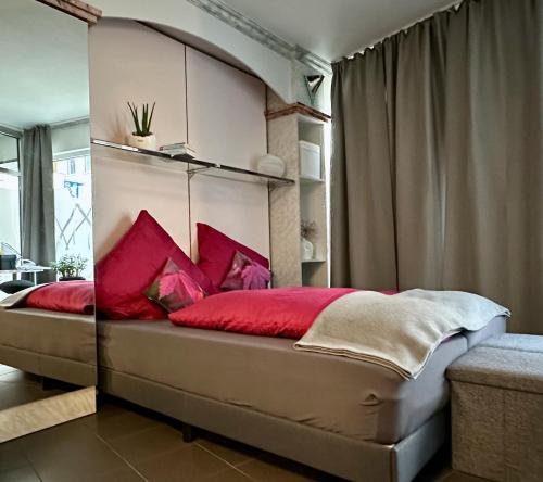 a bedroom with a large bed with red pillows at Studio im Herzen Meiningen -Erdgeschoss- in Meiningen
