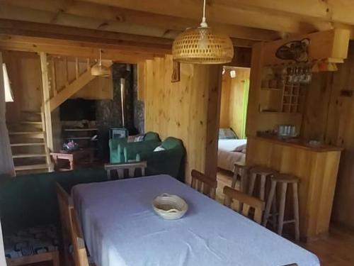 een kamer met een tafel en stoelen en een slaapkamer bij Cabaña Sector La Vaina, Lago Lanalhue in Cañete