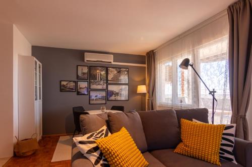 sala de estar con sofá marrón con almohadas amarillas en Apartman NEBO en Vinkovci