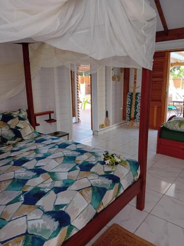 1 dormitorio con 1 cama con un edredón colorido en Aichi lodges gîtes en Capesterre