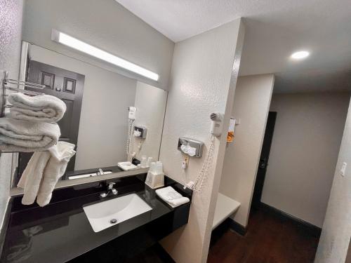 a bathroom with a sink and a mirror at Rodeway Inn in Georgetown
