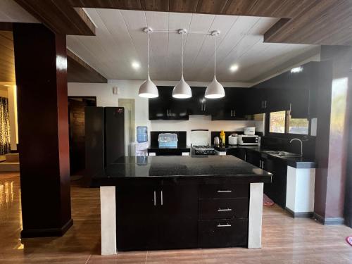 una cucina con armadi neri e piano di lavoro nero di Villa Valencia Private Resort a Santa Rita