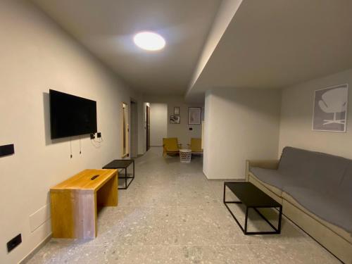 a living room with a couch and a flat screen tv at Apartments Du Parc in Sauze dʼOulx