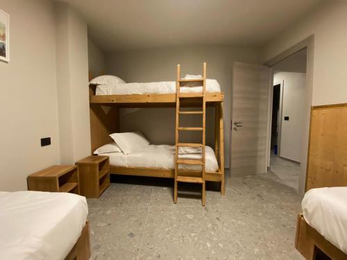 a room with two bunk beds and a ladder at Apartments Du Parc in Sauze dʼOulx