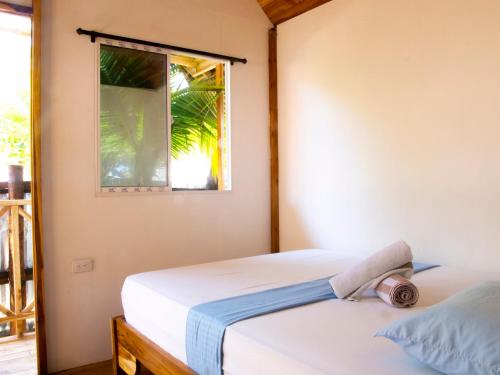 1 Schlafzimmer mit 2 Betten und einem Fenster in der Unterkunft Mithival Beach Rincón del Mar in Rincón