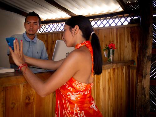a woman in a red dress standing at a counter at Mithival Beach Rincón del Mar in Rincón