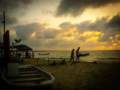 a group of people walking on the beach at sunset at Mithival Beach Rincón del Mar in Rincón