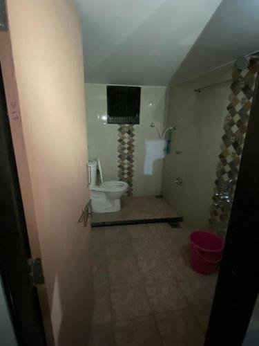 a bathroom with a toilet and a television on the wall at Laxmi Kunj in Akalkot