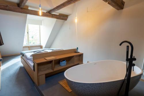 a bathroom with a bath tub and a bed at Gästehaus Liebfrauen in Wernigerode