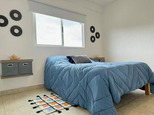 1 dormitorio con 1 cama con edredón azul en Departamento Esperanza, en Cancún