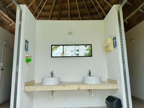 a bathroom with two sinks on a white wall at Departamento Esperanza in Cancún