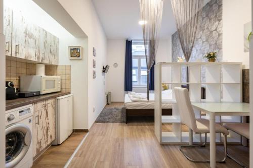 ブダペストにあるSilver Home Apartments in the city centreのキッチン、リビングルーム(テーブル、ベッド付)