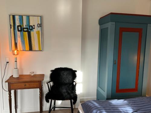 a bedroom with a bed and a chair and a desk at Lindegaardens Bed and Breakfast in Viby