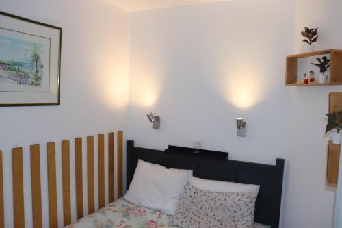 une chambre avec un lit et un tableau au mur dans l'établissement T2 climatisé wifi piscines parking, à Saint-Raphaël