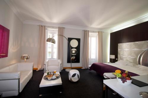 Una habitación de hotel con una cama y una sala de estar. en Suite Prado, en Madrid