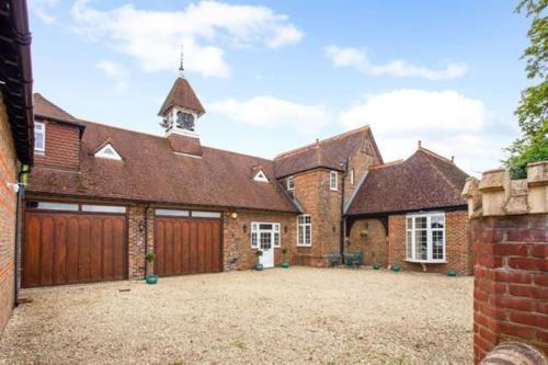 an exterior view of a brick house with a garage at Stunning Coach House in Sussex in Twineham