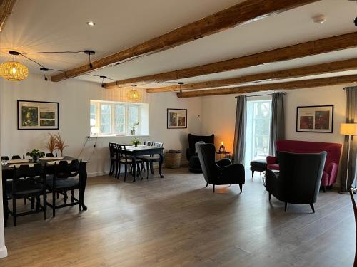 a living room with tables and chairs and a dining room at Lindegaardens Bed and Breakfast in Viby