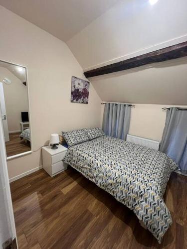 a small bedroom with a bed and a mirror at Haven - Beautiful 3 Bedroom house in Ballynahinch