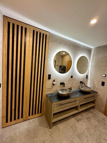 a bathroom with two sinks and two mirrors at Residence Smržovka - Luxury House with Swimming Pool, Jacuzzi, Garden and BBQ in Jablonec nad Nisou
