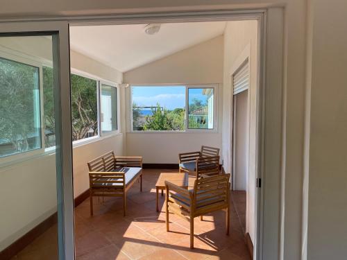 une chambre avec des chaises, une table et des fenêtres dans l'établissement Appartements 300 mètres de la mer et villa, à Saint-Florent