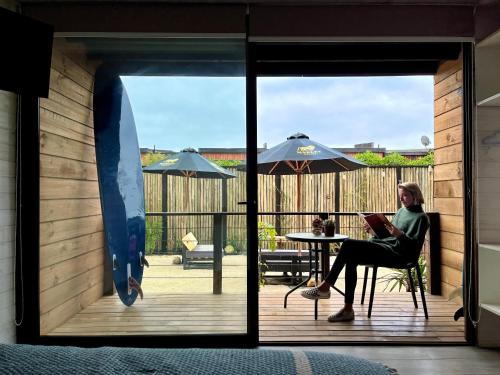 a woman sitting in a chair on a patio at Viento Bravo Hotel Boutique & Spa in Pichilemu