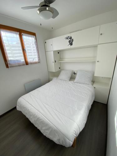 une chambre avec un lit blanc et une fenêtre dans l'établissement Maison avec jardin Résidence Horizon Bleu Vendres, à Vendres