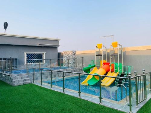 a playground with a slide and a swimming pool at استراحة زهرة الاماكن 2 in Jeddah