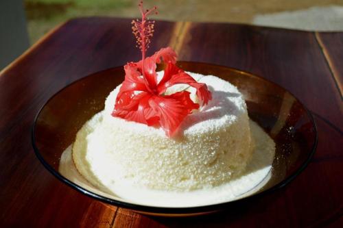 a cake on a plate on a wooden table at Pousada Natureza Viva in Itacaré