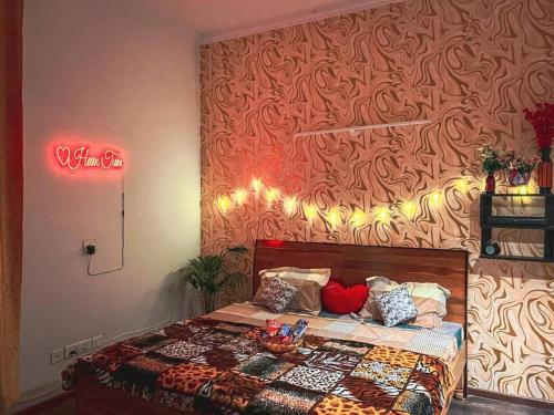 1 dormitorio con 1 cama con pared roja en Love Lounge - Luxury 3BHK Villa in Greater Noida en Noida