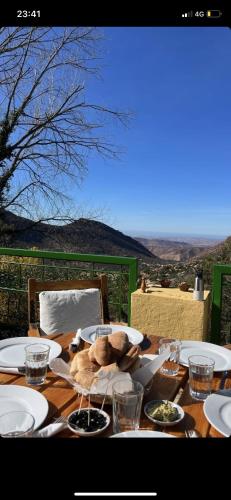 a wooden table with plates of food on it at Auberge des Cascades Imouzzer - Paradise Valley in Imouzzer des Ida Ou Tanane