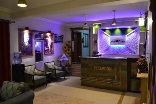 a room with a television and a bar at Fusion Lodge in Islamabad