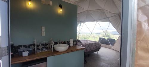 ein Bad mit einem Waschbecken und ein Bett in einem Zelt in der Unterkunft Pura Vista Glamping in El Castillo de La Fortuna