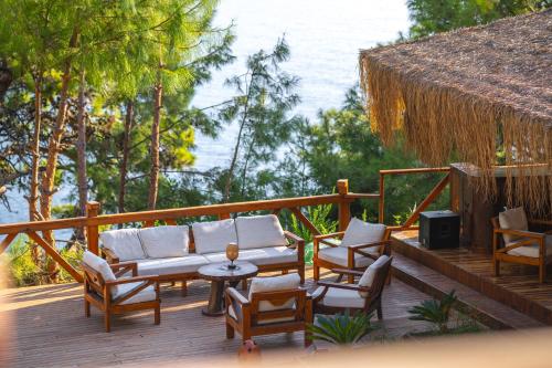 a deck with chairs and a couch and a table at La Boheme Kabak Adults Only in Faralya