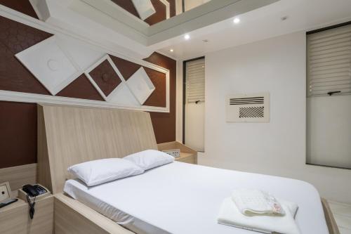 um quarto com uma cama branca num quarto em Motel Disco Verde Congonhas 1 em São Paulo