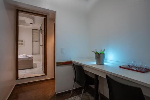 uma casa de banho com um balcão com cadeiras e um espelho em Motel Disco Verde Congonhas 1 em São Paulo