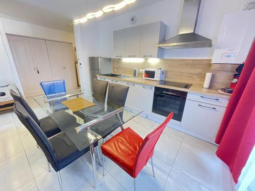 a kitchen with a glass table and some chairs at nuovo appartamento saint louis 68300 tra francia e svizzera in Saint-Louis