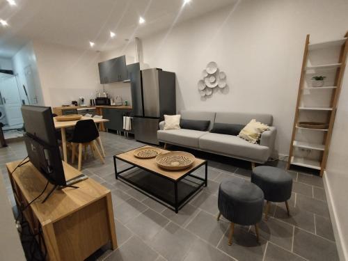 un salon avec un canapé et une table dans l'établissement Le Refuge des Voyageurs, à Conflans-sur-Seine