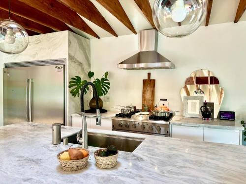 a kitchen with a sink with two baskets of fruit at Spacious Resort Getaway @ Echo Park Ranch - Luxury indoor/ outdoor home steps from Sunset Blvd, Echo Park Lake, Dodgers Stadium in Los Angeles
