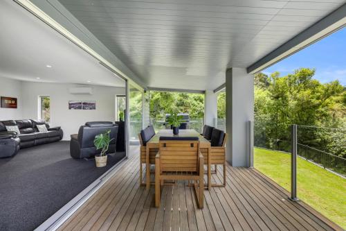 a living room with a table and chairs on a deck at Tarawera Paradise in Rotorua
