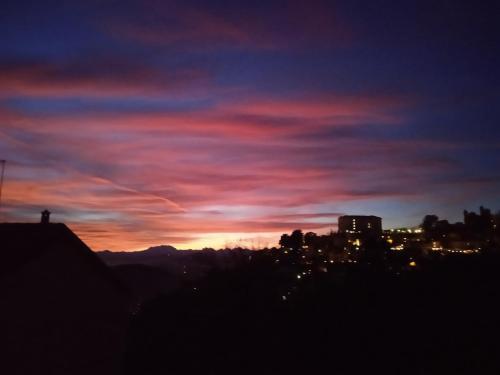a sunset in the sky with a city in the background at Alle Vigne 5 in Brunate