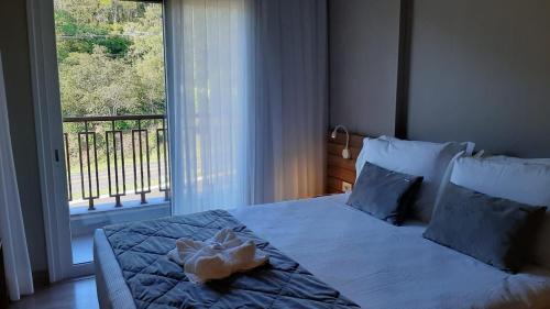 un dormitorio con una cama con un animal de peluche en Golden Laghetto Gamado en Gramado