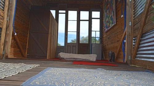 an inside view of a room with windows and a rug at Ladomar Cabañas in La Esmeralda 