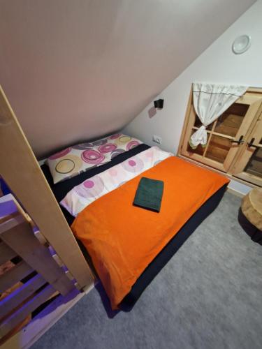 a bedroom with a bunk bed with an orange blanket at Domek rekreacyjny U Marcina in Kwidzyn